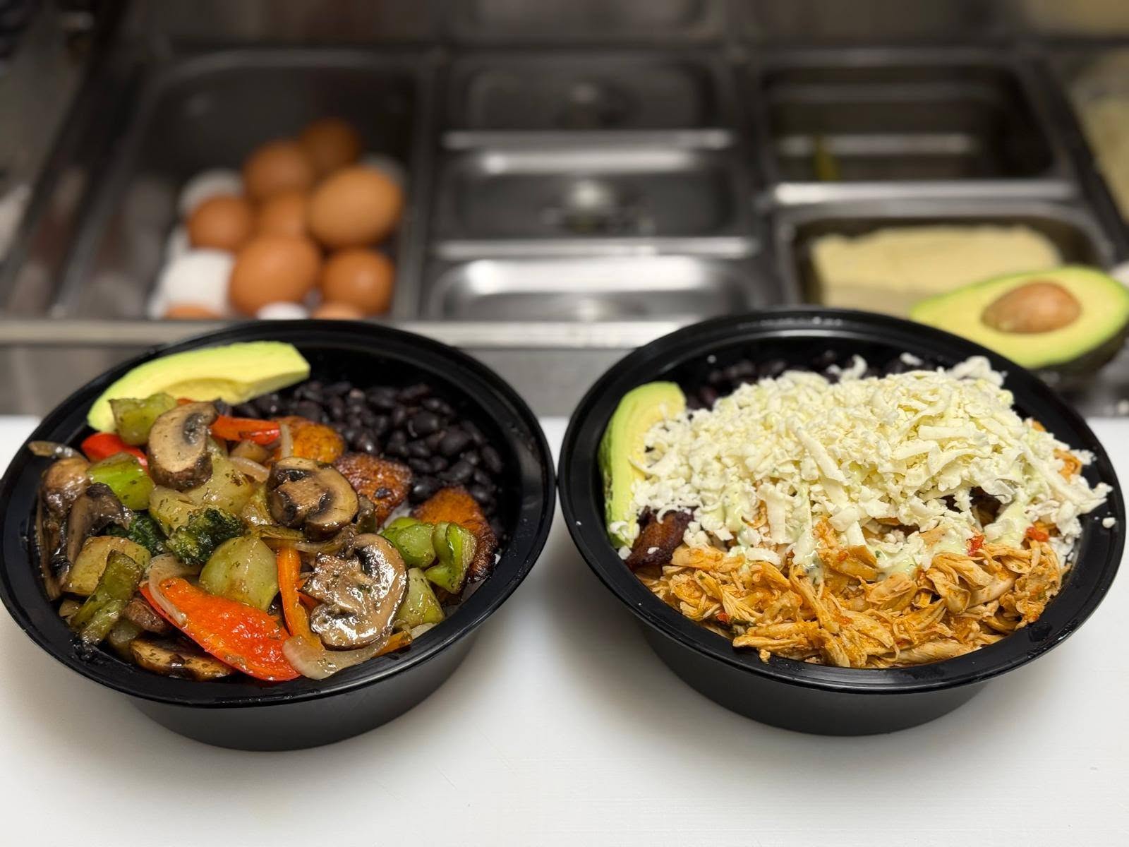 A veggie bowl and a shredded-meat criollo-style bowl at the 1Chick 1Bro kitchen pass