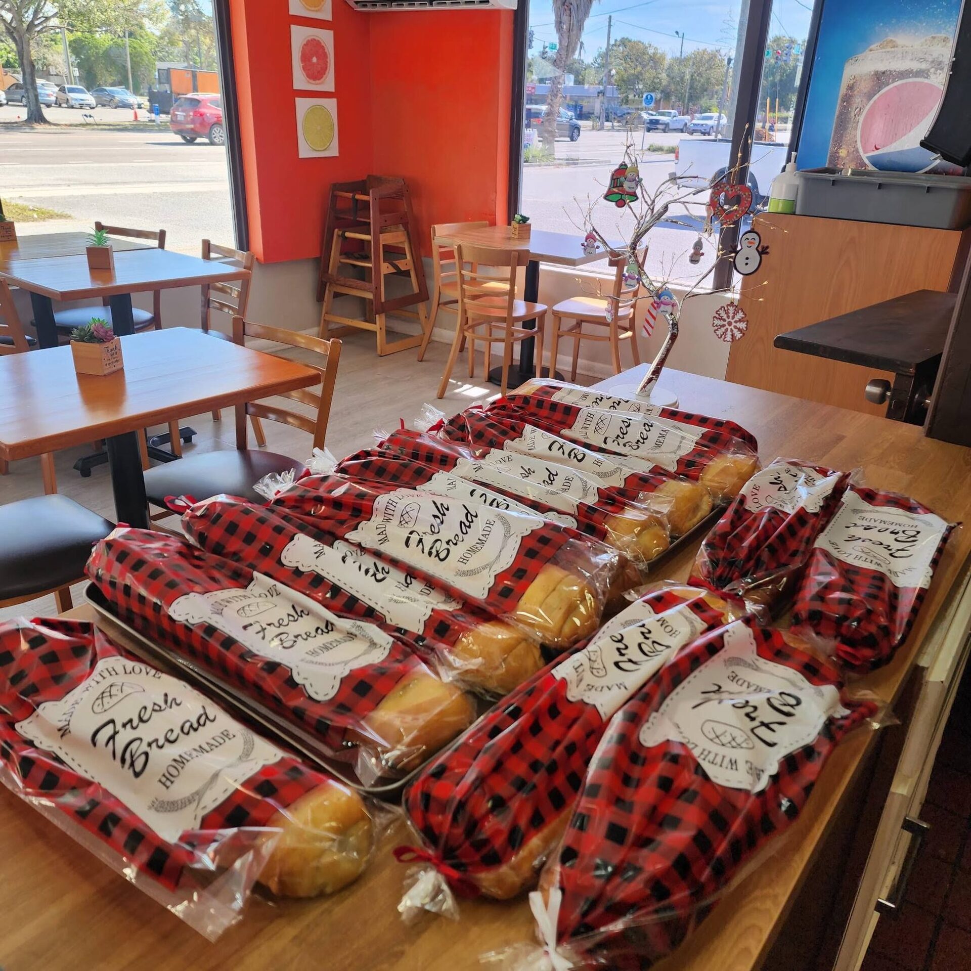 Loaves of 1Chick 1Bro pan de jamón wrapped in buffalo-check paper on the dining tables at Christmas