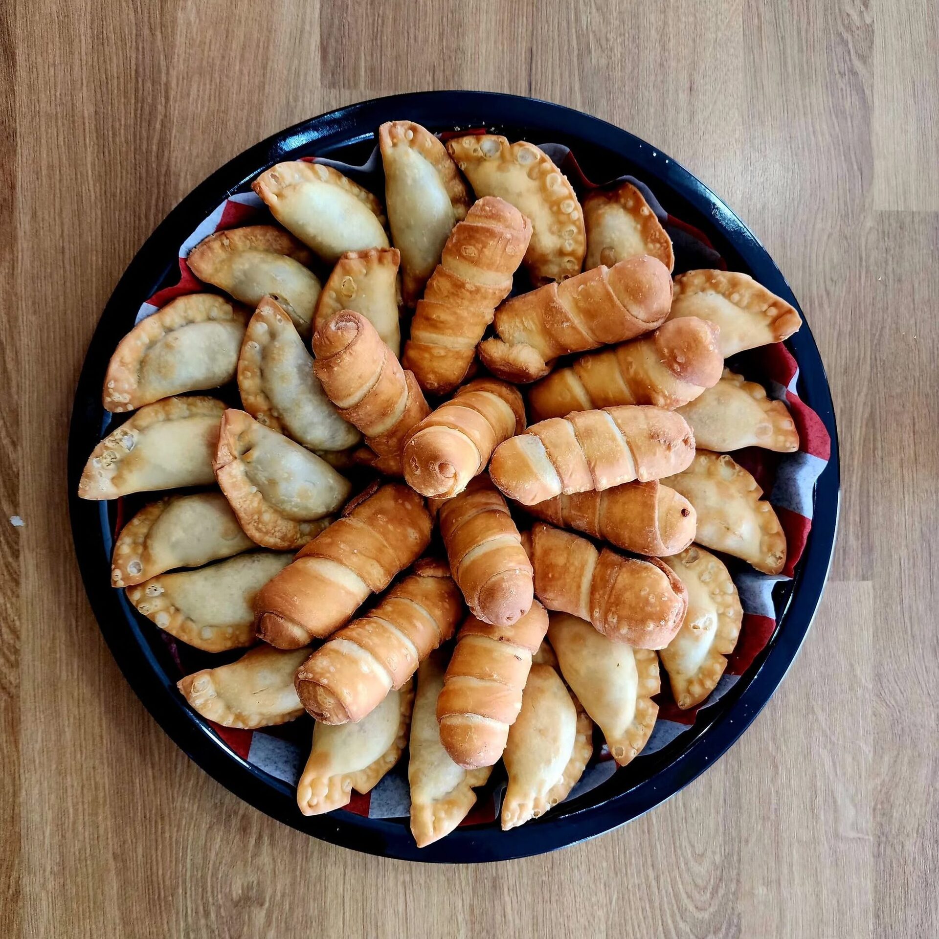 Overhead view of a platter of tequeños and empanadas